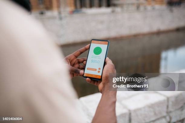 one man using a smart phone outdoors - moneytransfer stock pictures, royalty-free photos & images