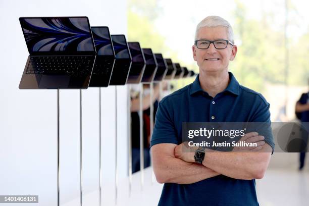 Apple CEO Tim Cook looks at a display of brand new redesigned MacBook Air laptop during the WWDC22 at Apple Park on June 06, 2022 in Cupertino,...