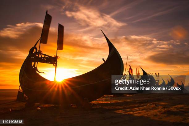 silhouette of moored viking ships on beach against sky during sunset,bangladesh - attraccato foto e immagini stock