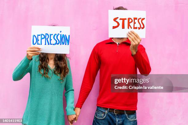 young couple holding hands with stress and depression, mental health - couple placard stock pictures, royalty-free photos & images