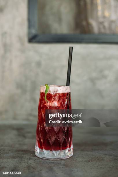 té helado de hibisco con menta fresca sobre un fondo gris - rosella carmesí fotografías e imágenes de stock