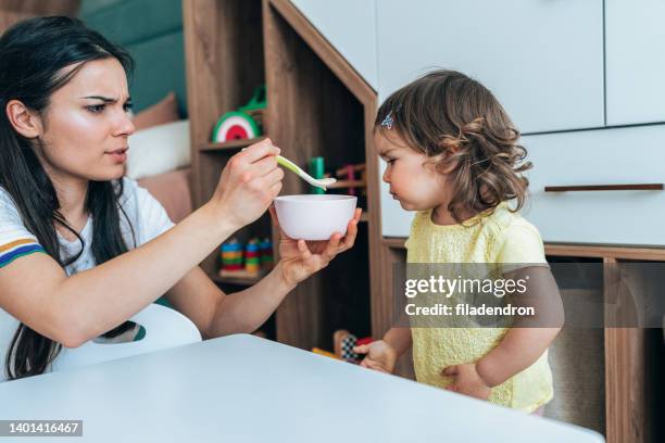 mother feeding her girl - angry parent mealtime stock pictures, royalty-free photos & images