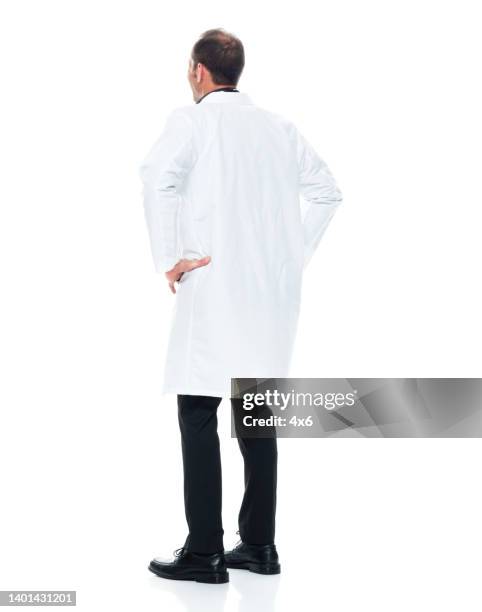 kaukasische junge männliche arzt steht vor weißem hintergrund tragen labormantel - laborkittel stock-fotos und bilder