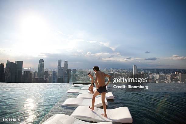 Hotel guests are seen at the infinity pool at the SkyPark atop Marina Bay Sands in Singapore, on Tuesday, Feb. 28, 2012. The number of visitors to...