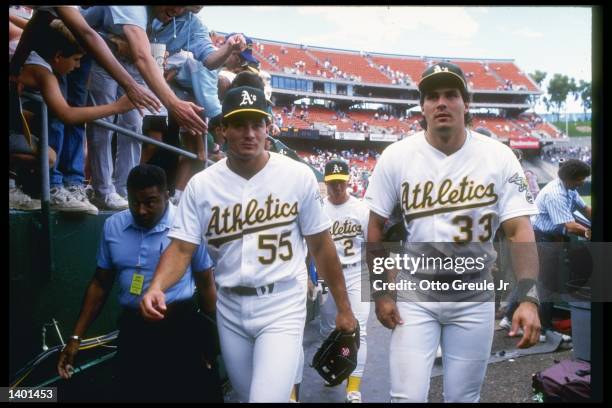 Outfielder Jose Canseco of the Oakland Athletics walks with his brother and teammate Ozzie Canseco. Mandatory Credit: Otto Greule /Allsport