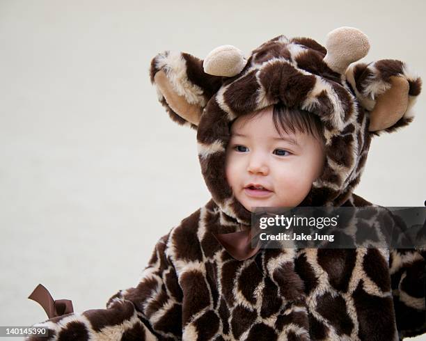 young girl wearing giraffe-patterned coat - animal pattern stock pictures, royalty-free photos & images