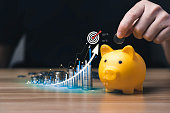 business people save money in piggy bank and goal and achievement chart graph and arrows. Concept Buying Funds Loans and Investment Profits. accumulate assets, wealth, lucrative