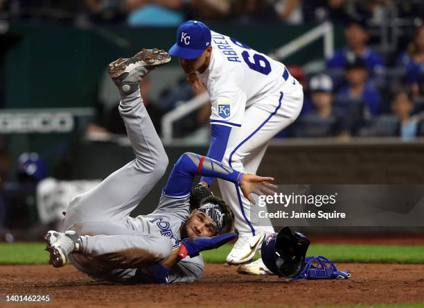 Lourdes Gurriel Jr. #13 of the Toronto Blue Jays collides with pitcher Albert Abreu of the Kansas City Royals while sliding into home plate to score...