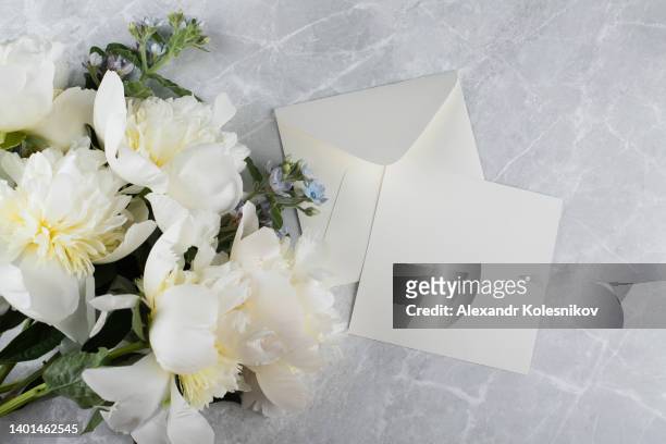 minimal styled flat lay with cream peony flower and empty blank card with envelope. mock up concept. top view, flat lay - white flower paper stock pictures, royalty-free photos & images