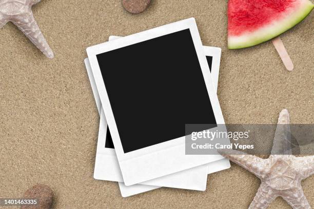 stack of blank instant print transfer with instant camera in sand beach.summer memories - film collector stock pictures, royalty-free photos & images