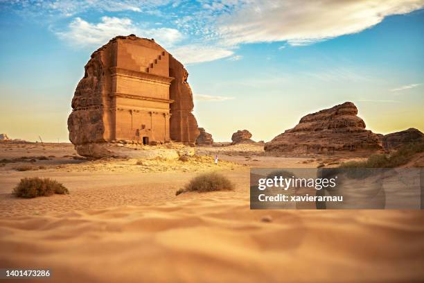 distant view of saudi man exploring hegra in medina region - middle east landscape stock pictures, royalty-free photos & images