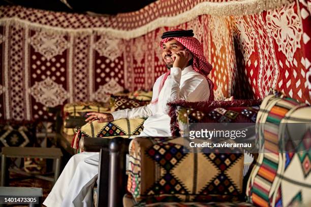joven de oriente medio relajándose dentro de beit al-sha'r - beduino fotografías e imágenes de stock