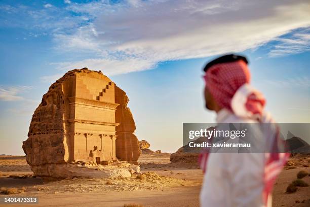 man admiring tomb of lihyan, son of kuza, at hegra - 瑪甸沙勒 個照片及圖片檔