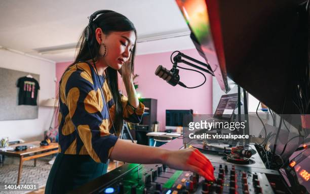 young dj making a online music set for her listeners - mood stream stock pictures, royalty-free photos & images