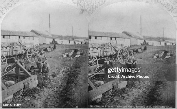 Stereoscopic image showing a prisoner is seen sitting on the chassis of a cart, with views of the machine shop, rolling mill and carpenter shop in...