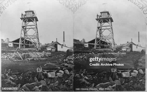 Stereoscopic image showing a guard standing atop a watchtower, or 'high post,' as the figure of a prisoner is seen sitting on a stone wall in the...