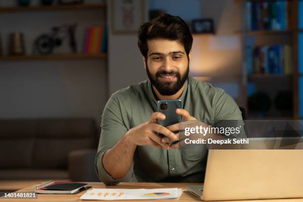 handsome young man in working on laptop stock photo - handsome indian guys stock pictures, royalty-free photos & images