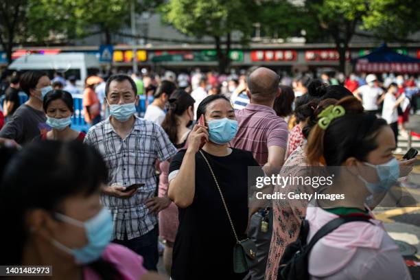 The women uses iPhone while wait to pick up students outside one of the national college entrance exam venues on June 7, 2022 in Wuhan, Hubei...