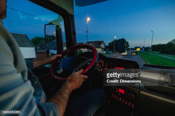 a focused truck driver holding steering wheel of a truck - truck turning stock pictures, royalty-free photos & images
