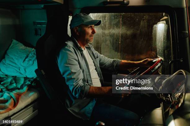 truck driver driving long distance at night - trucker stockfoto's en -beelden