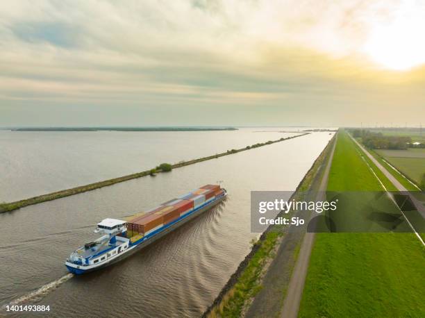 container ship barge sailing on a canal - scheepvaart stockfoto's en -beelden