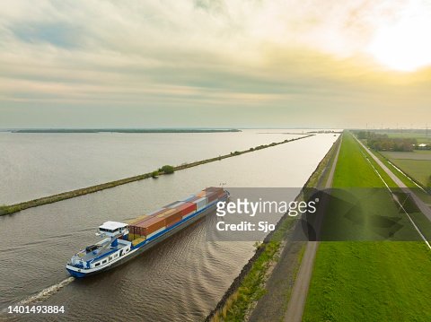 Container ship barge sailing on a canal