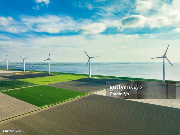 wind turbines on the shore of a lake - environmental issues stockfoto's en -beelden