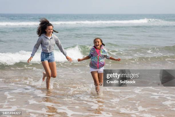 a splash in the cold sea - beach holiday uk stock pictures, royalty-free photos & images