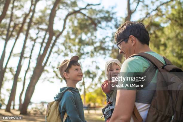 family enjoying time toghether - baby carrier stock pictures, royalty-free photos & images
