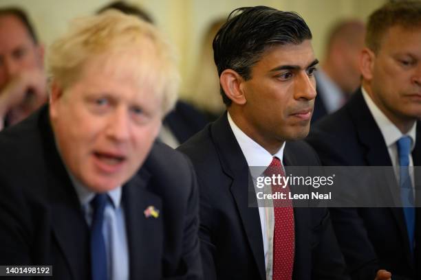 Britain's Chancellor Rishi Sunak listens as Prime Minister Boris Johnson addresses his Cabinet ahead of the weekly Cabinet meeting in Downing Street...