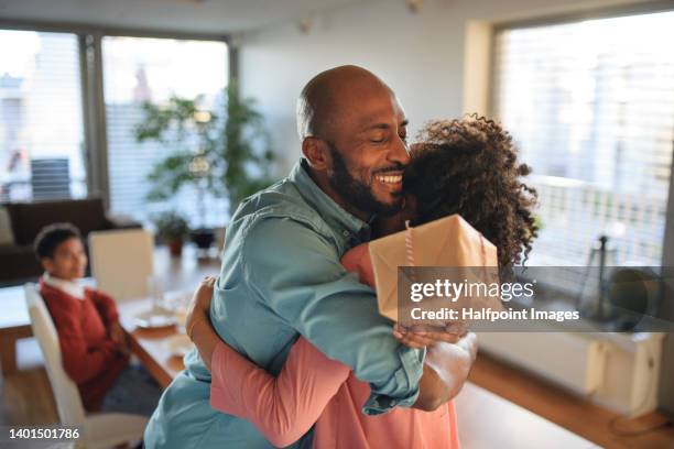 cheerful african american father getting present by her daughter, celebrating. - daughter birthday stock pictures, royalty-free photos & images