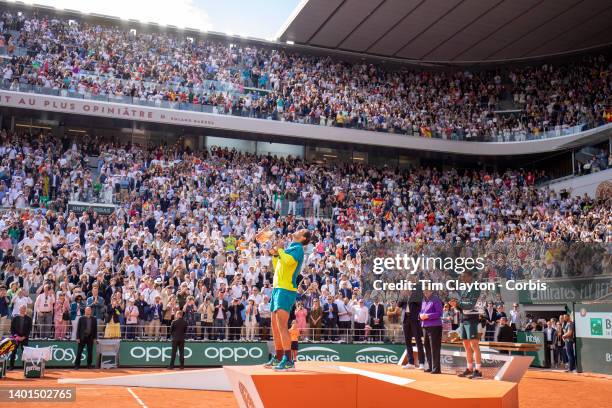 Rafael Nadal of Spain raises the winners trophy watched by French Tennis Federation President Gilles Moretton, Billie Jean King and Casper Rudd after...