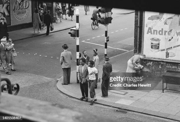 People strolling on Atlantic Road in Brixton, London, UK, 1952. Original Publication: Picture Post - 6044 - Breeding A Colour Bar - Volume 56 Issue...