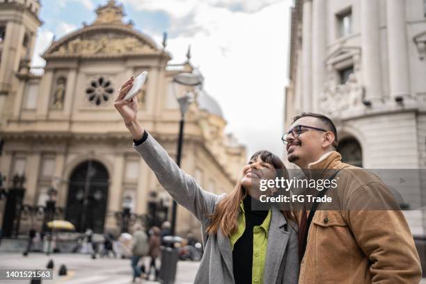 young couple taking selfies in front of a basilica in buenos aires, argentina - buenos aires landmarks stock pictures, royalty-free photos & images