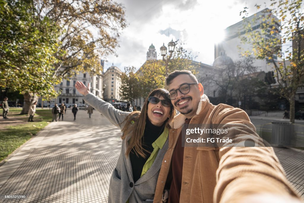 Selfie of a happy young couple exploring the city