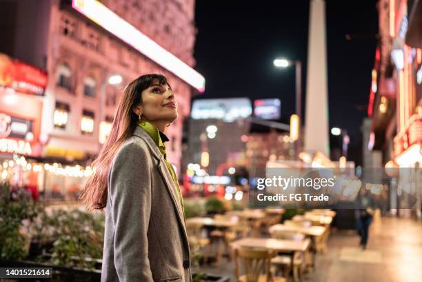 young woman contemplating city lights at night - buenos aires night stock pictures, royalty-free photos & images