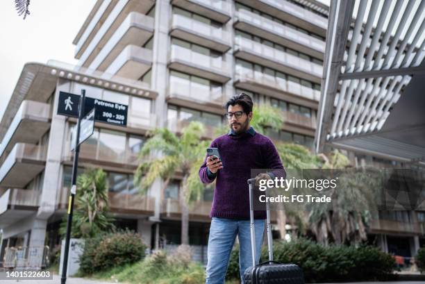 businessman with luggage using smartphone waiting a cab - uber in buenos aires argentina stock pictures, royalty-free photos & images