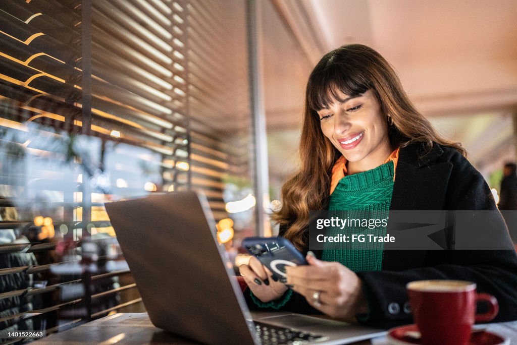 Businesswoman working using smartphone in a restaurant