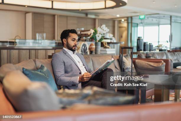 business travel - indian businessman waiting in an airport lounge - airport waiting lounge imagens e fotografias de stock