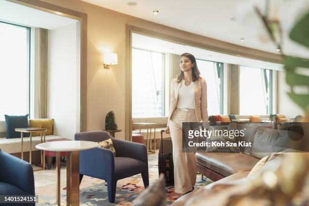 viaggi d'affari - ricca donna d'affari indiana che si dirige verso l'imbarco sul suo volo dalla sala vip - asian luxury lifestyle foto e immagini stock