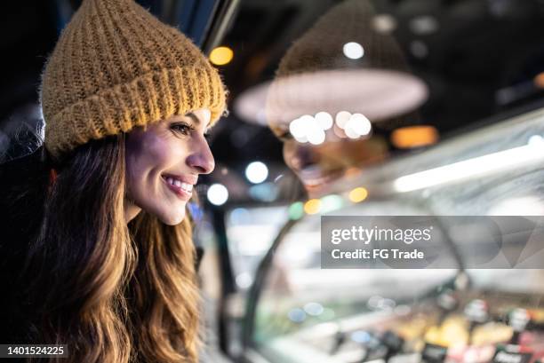 junge frau schaut auf eistheke - ice cream counter stock-fotos und bilder