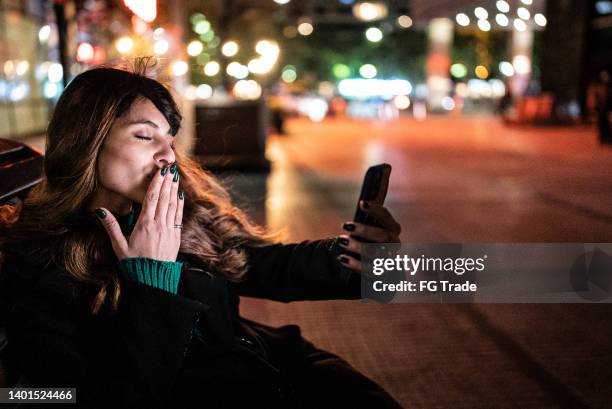 young woman on a video call on the mobile phone in the street - tourist talking on the phone stock pictures, royalty-free photos & images