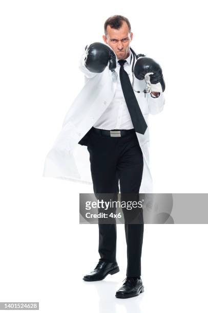 caucasian young male doctor standing in front of white background wearing glove - fighting stance stock pictures, royalty-free photos & images