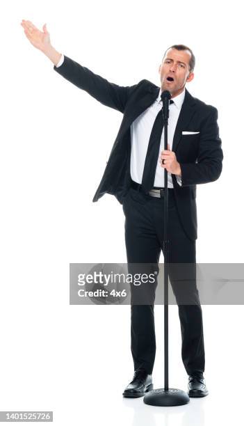 cantor caucasiano dançando na frente de fundo branco vestindo roupas de negócios e segurando suporte de microfone - microphone stand - fotografias e filmes do acervo