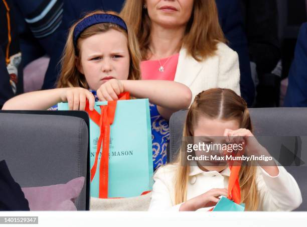 Mia Tindall and Princess Charlotte of Cambridge open their Fortnum & Mason gift bags as they attend the Platinum Pageant on The Mall on June 5, 2022...