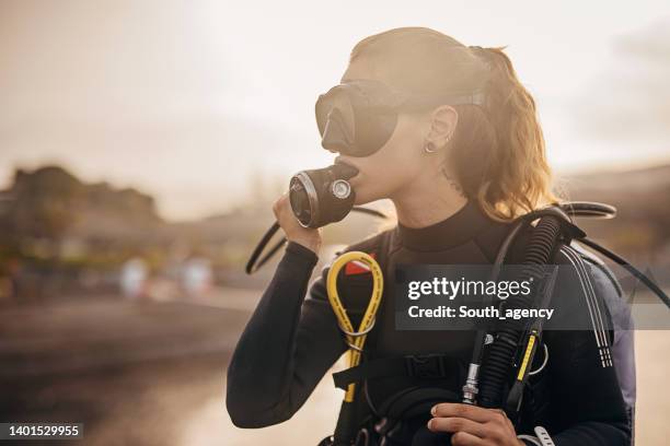 woman diver preparing for diving in the sea - aqualung diving equipment stock pictures, royalty-free photos & images