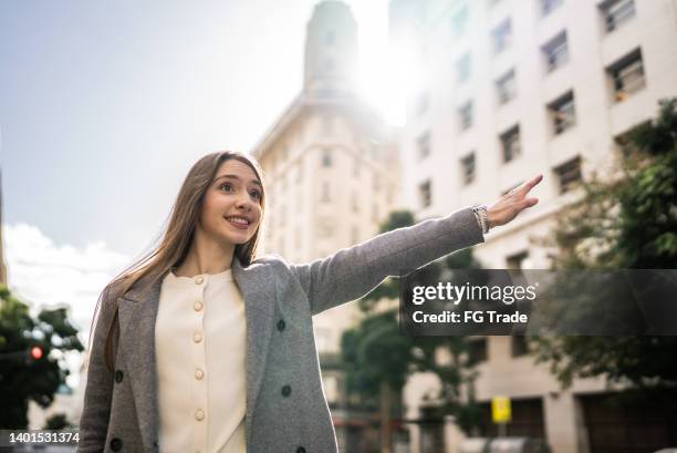 young businesswoman gesturing to get a cab - uber in buenos aires argentina stock pictures, royalty-free photos & images