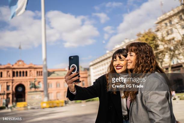 donne che scattano selfie sul cellulare per strada - casa rosada foto e immagini stock