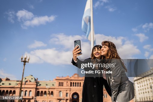 Frauen, die Selfies auf dem Handy auf der Straße machen Frauen, die Selfies auf dem Handy auf der Straße machen