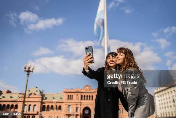 frauen, die selfies auf dem handy auf der straße machen - buenos aires stock-fotos und bilder